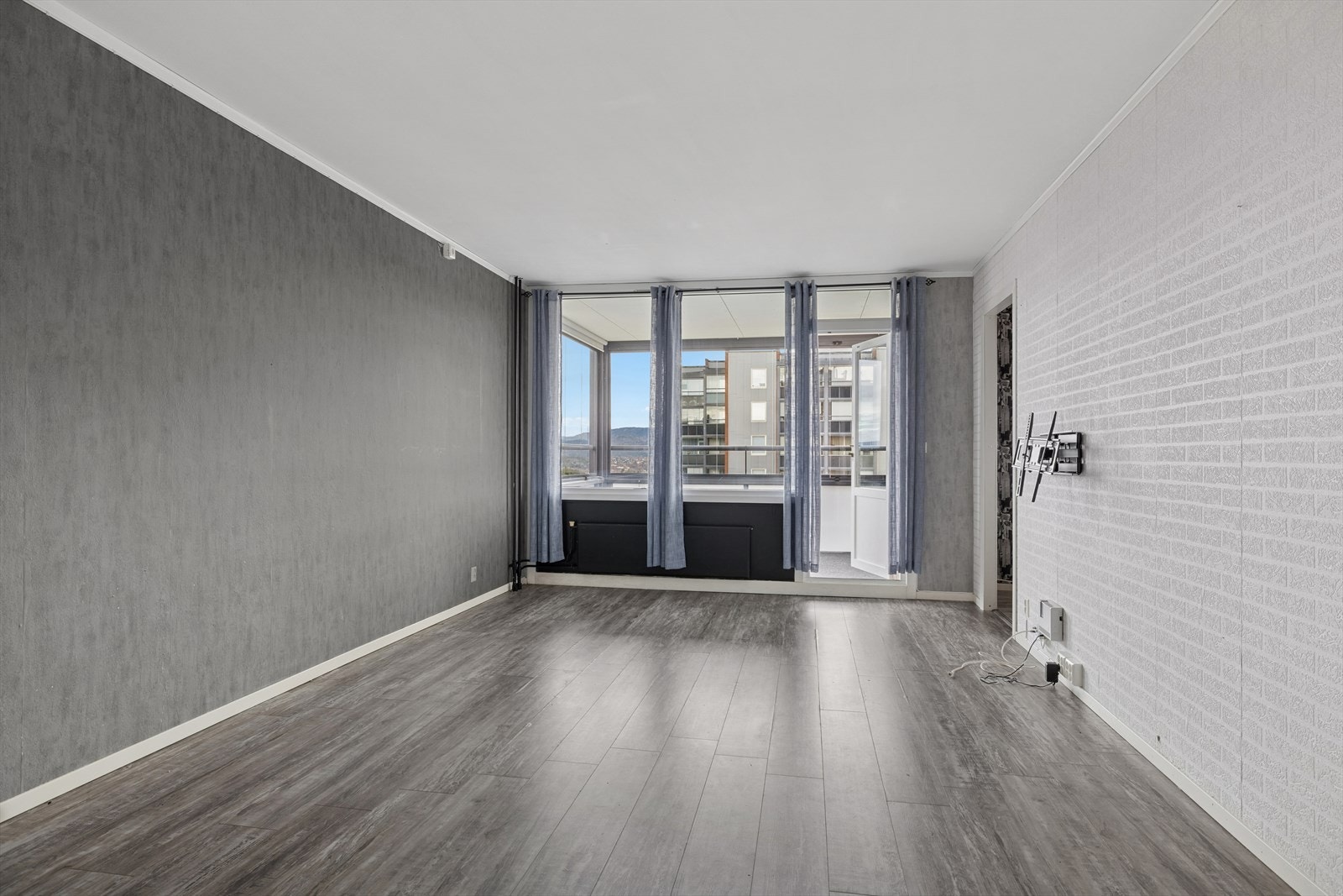 Romslig stue med tapet og laminatgulv på overflater. Galleribilde