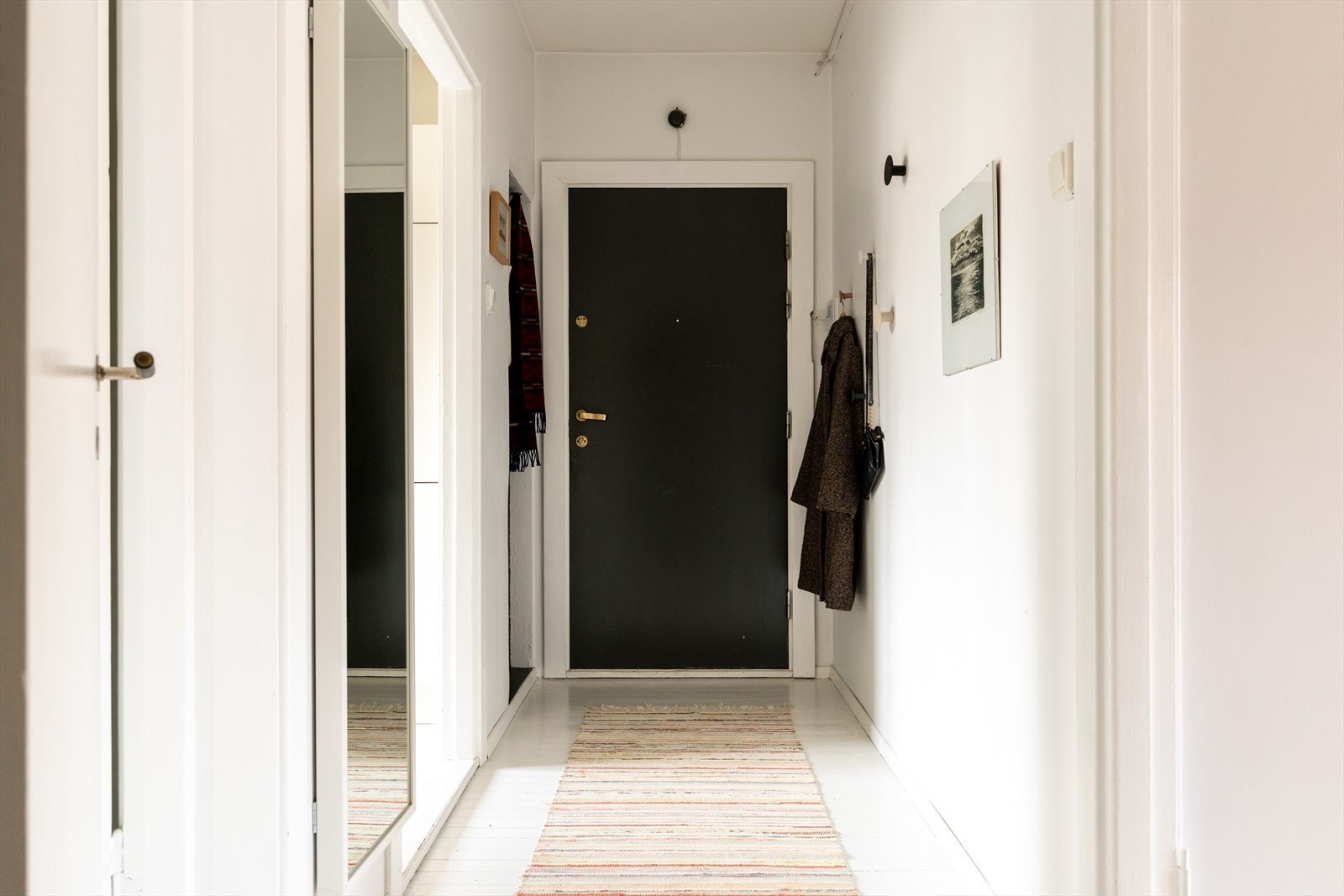 Gangen er smart utnyttet med veggoppheng for klær og vesker, som gir god plass og orden i hverdagen. Galleribilde