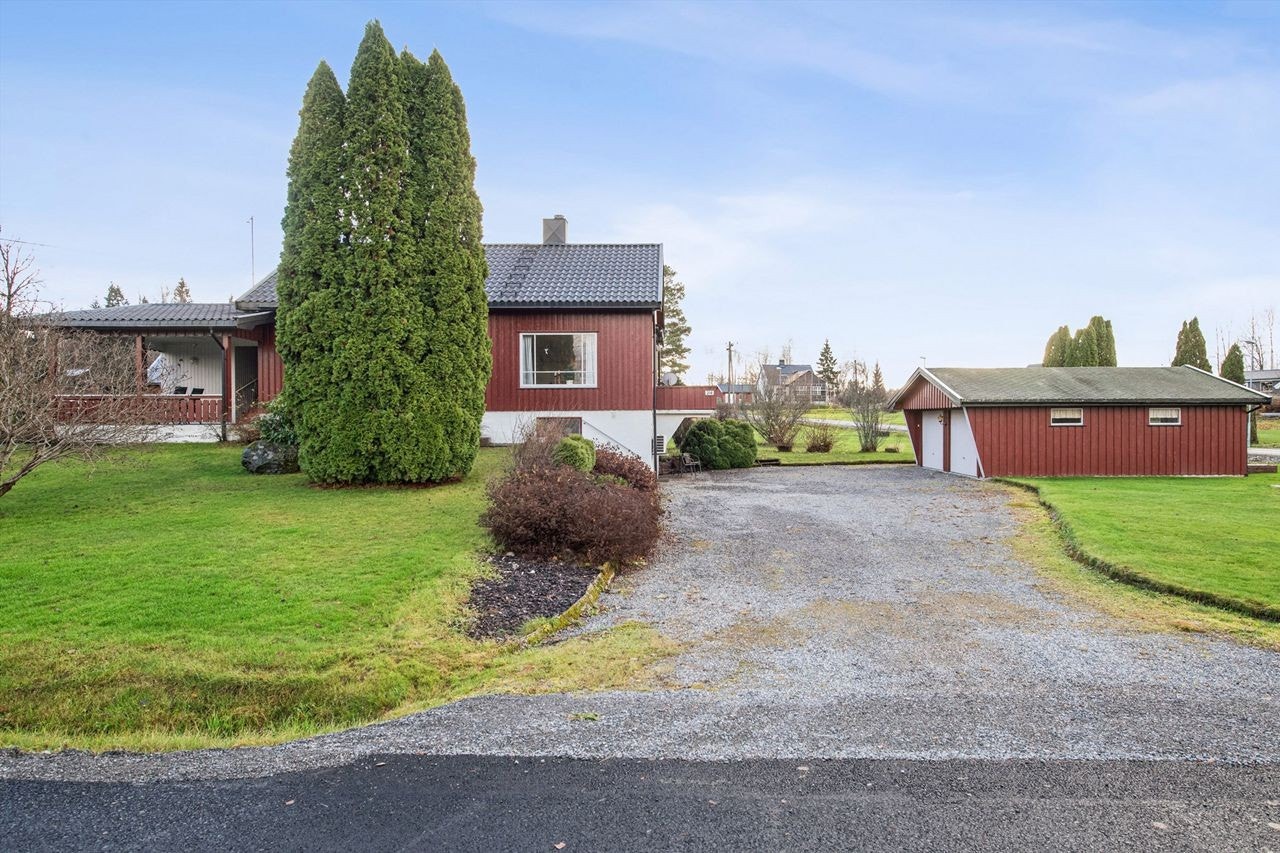 Eneboligen har en romslig, gruset innkjørsel og en frittstående dobbel garasje. Galleribilde