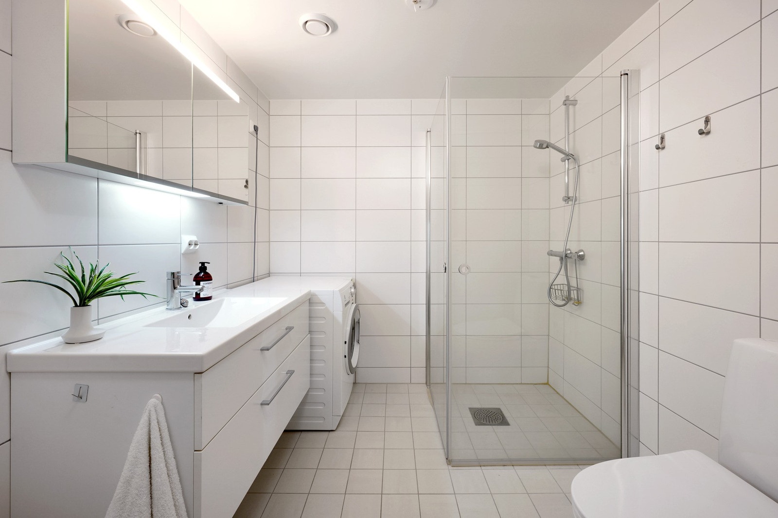 Stilrent bad i klassisk moderne uttrykk med tilrettelagt opplegg for vaskemaskin. Galleribilde