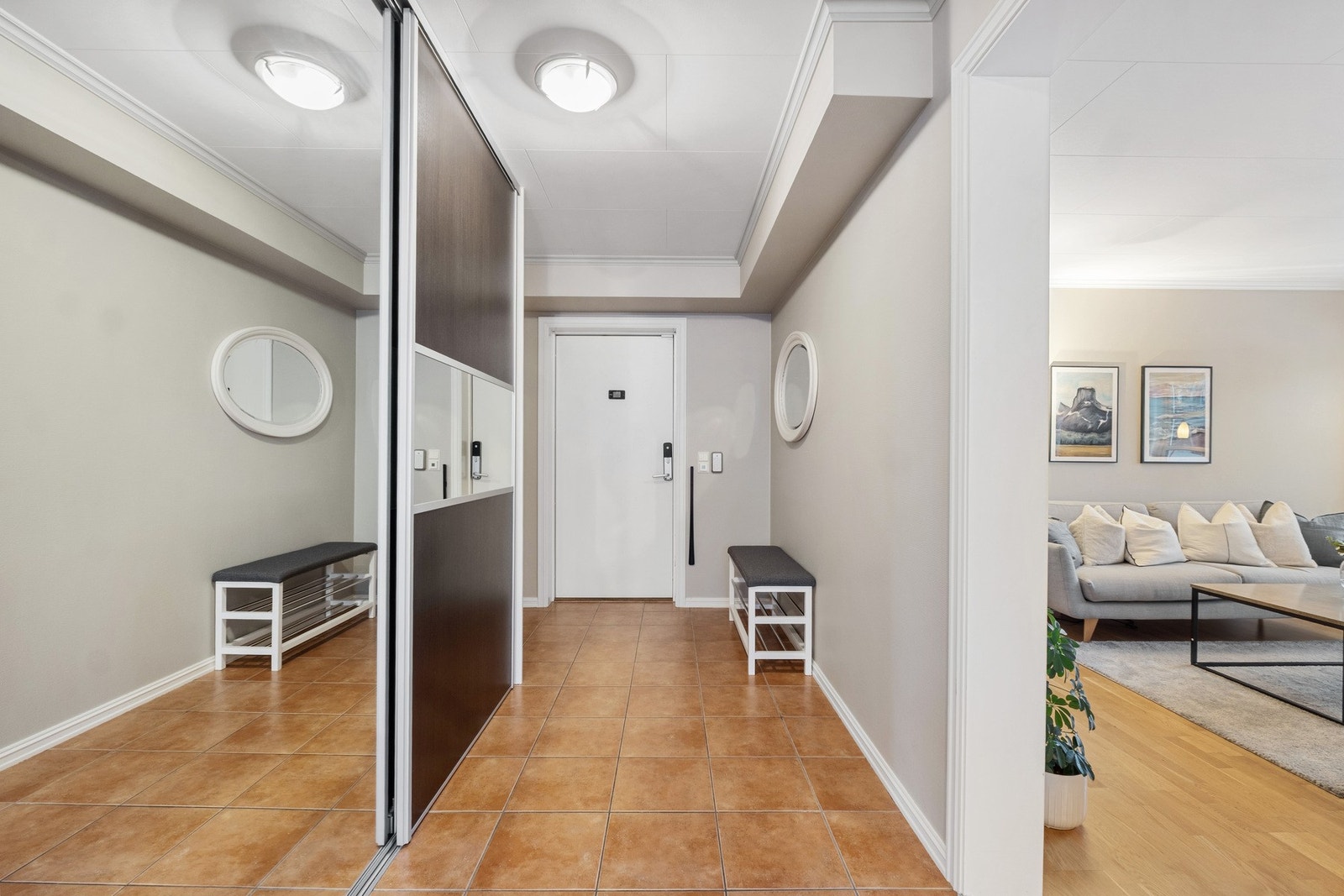 Innbydende og luftig entre med flislagt gulv med varmekabler og en romslig skyvedørsgarderobe. Galleribilde