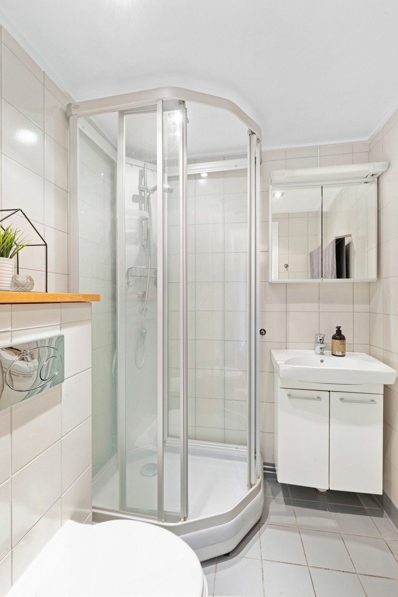 Pent flislagt bad med dusjkabinett, vegghengt wc og servant Galleribilde