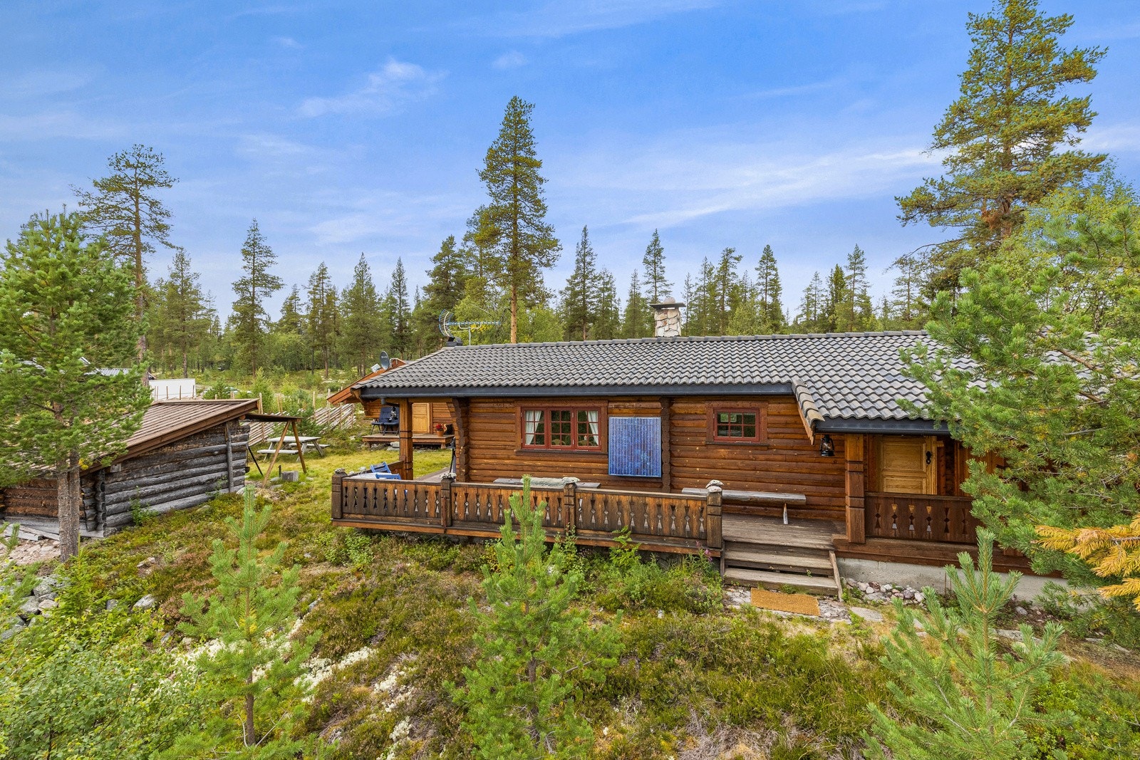 Hytta har fine uteareal både på terrassen rundt hytteveggen, i grillbua og i det fri. Hytta har en koselig adkomst med overbygd inngangsparti Galleribilde