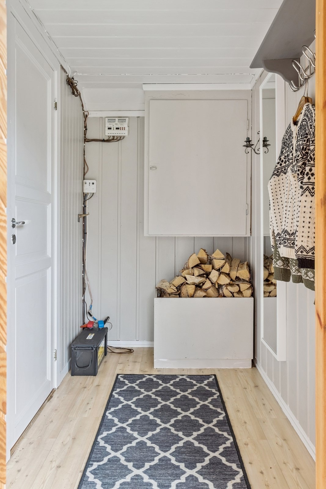 Praktisk entré med belegg på gulvet og plass til vedoppbevaring. Galleribilde