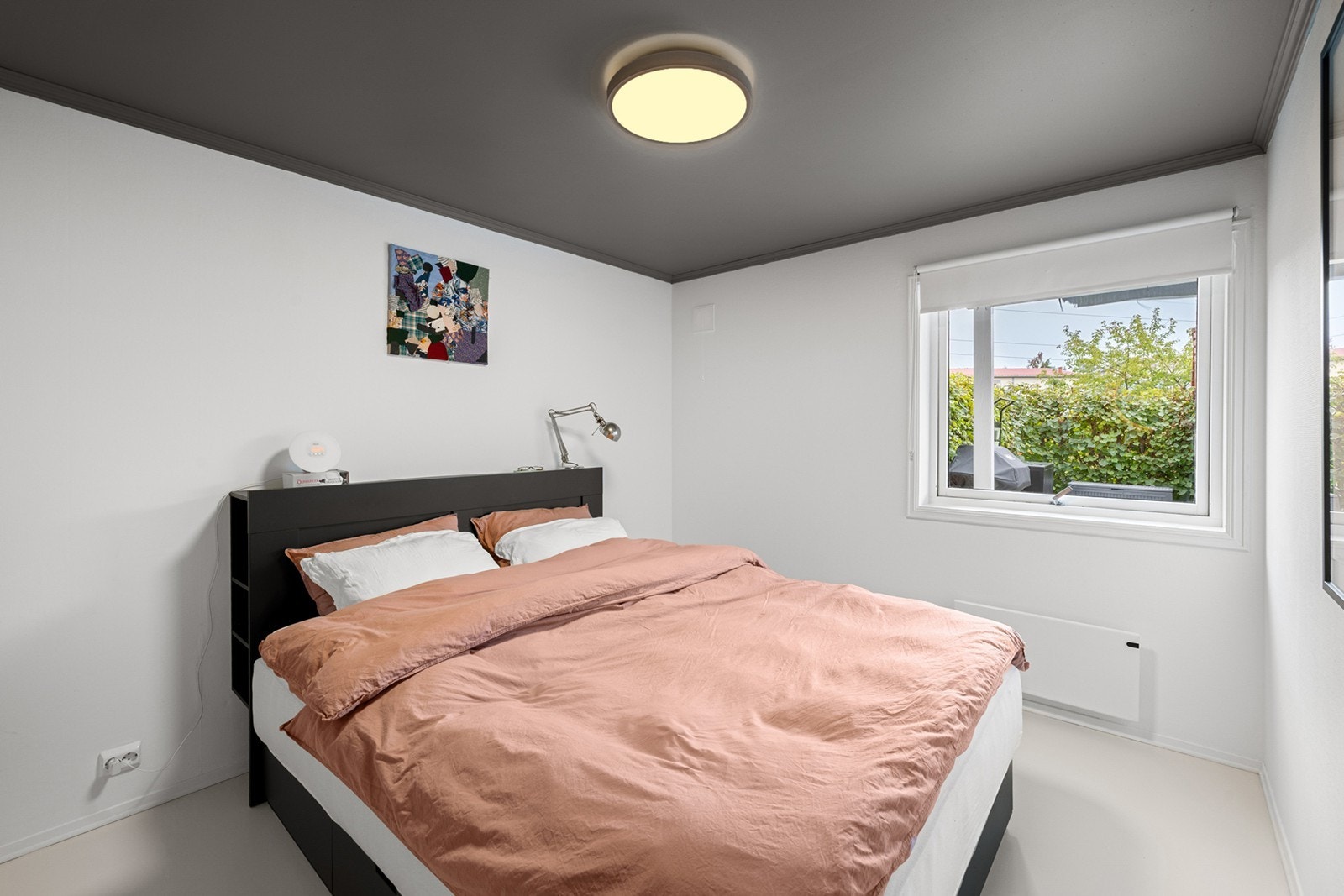 Soverom 1 - Lyst og romslig hovedsoverom med plass til dobbeltseng og nattbord. Store vindusflater slipper inn naturlig lys, og gir samtidig utsyn mot uteområdet. Galleribilde