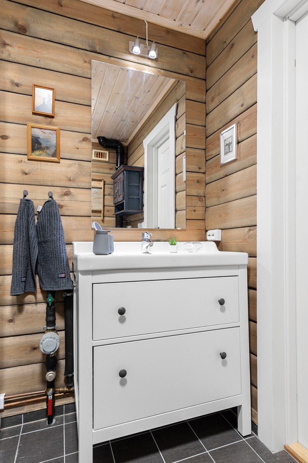 Servantkommoden har to store skuffer til håndklær og toalettsaker. Lampen over speilet er håndplukket. Galleribilde