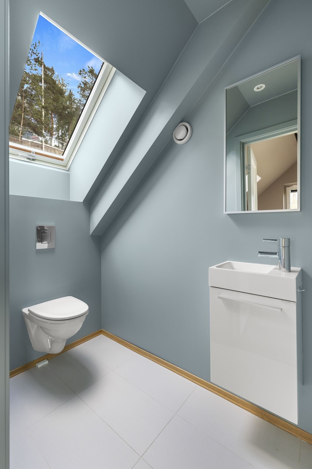 Wc-rommet er plassert i loftsetasjen og har store, hvite gulvfliser med varme. Galleribilde