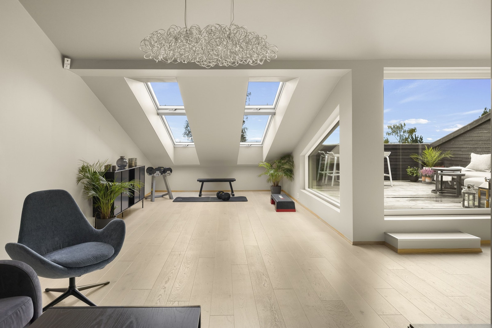 Øverst i trappen har stuen en varmepumpe, og en stor skyvedør i glass tar deg ut til den solrike takterrassen. Galleribilde