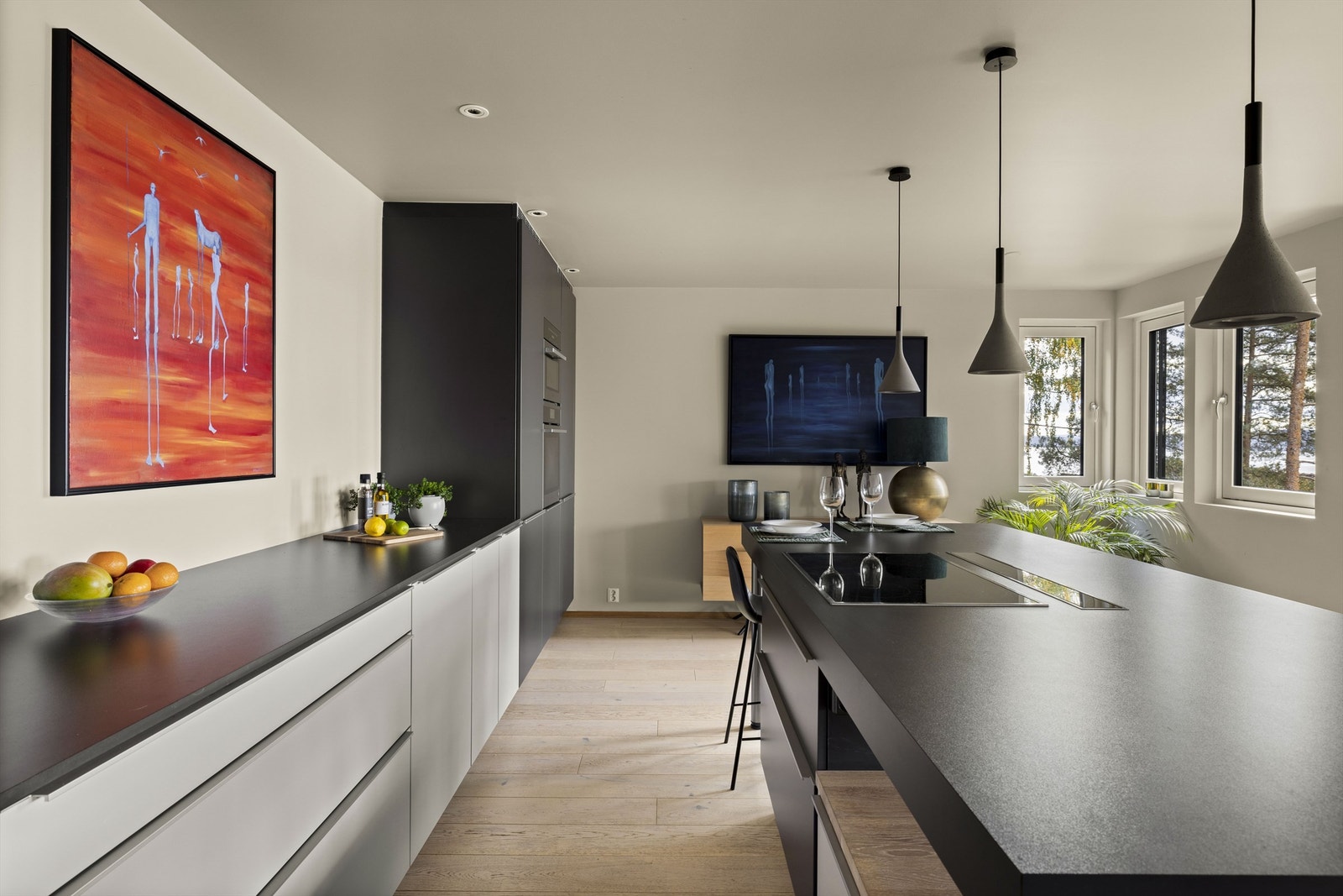 Innredningen har grå, glatte fronter, mørkere høyskap, høytrykkslaminert benkeplate og nedfelt oppvaskkum i rustfritt stål. Galleribilde