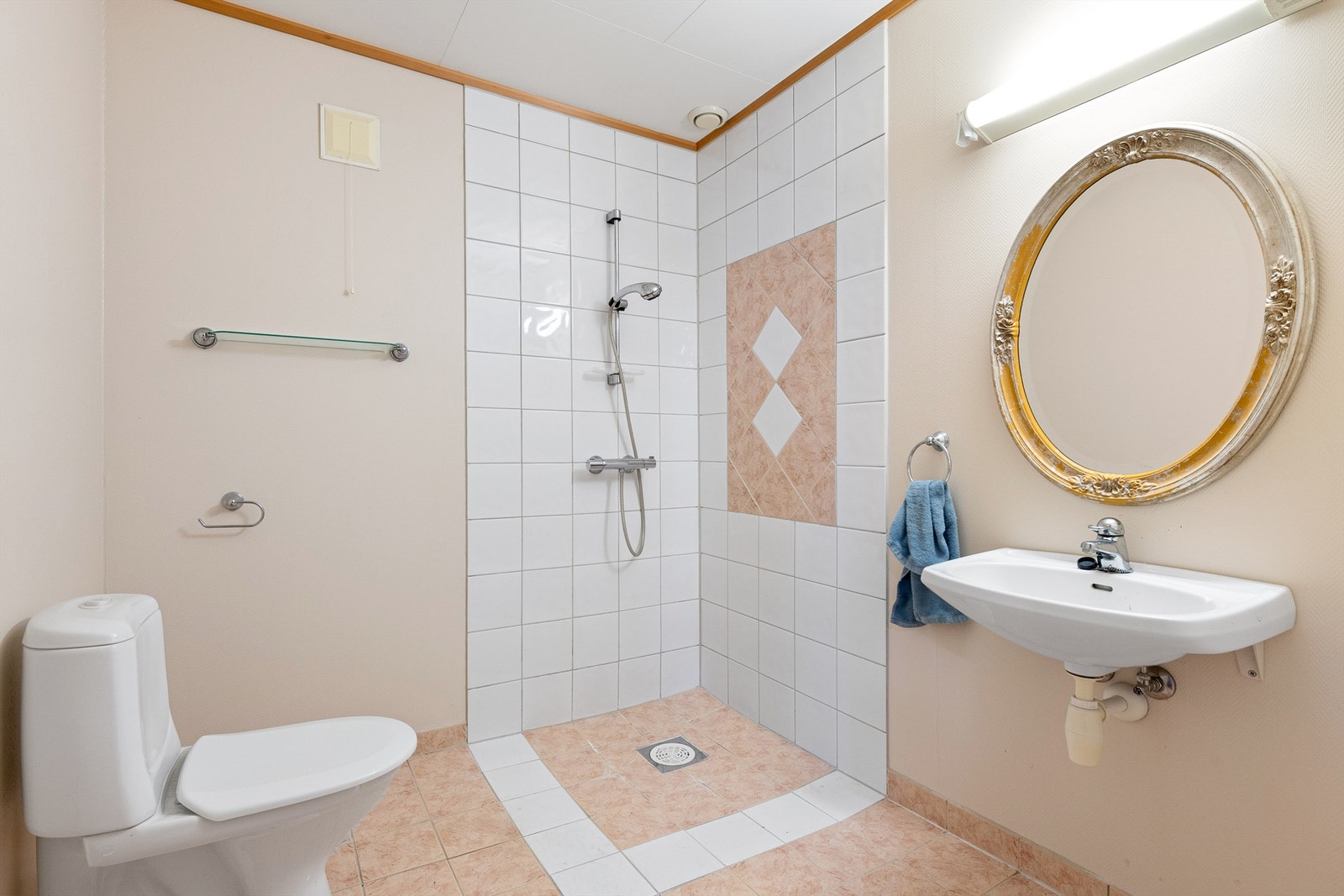 Flislagt bad i underetasjen, Dusjhjørne med vegghengt dusjarmatur. Servant og toalett. Galleribilde