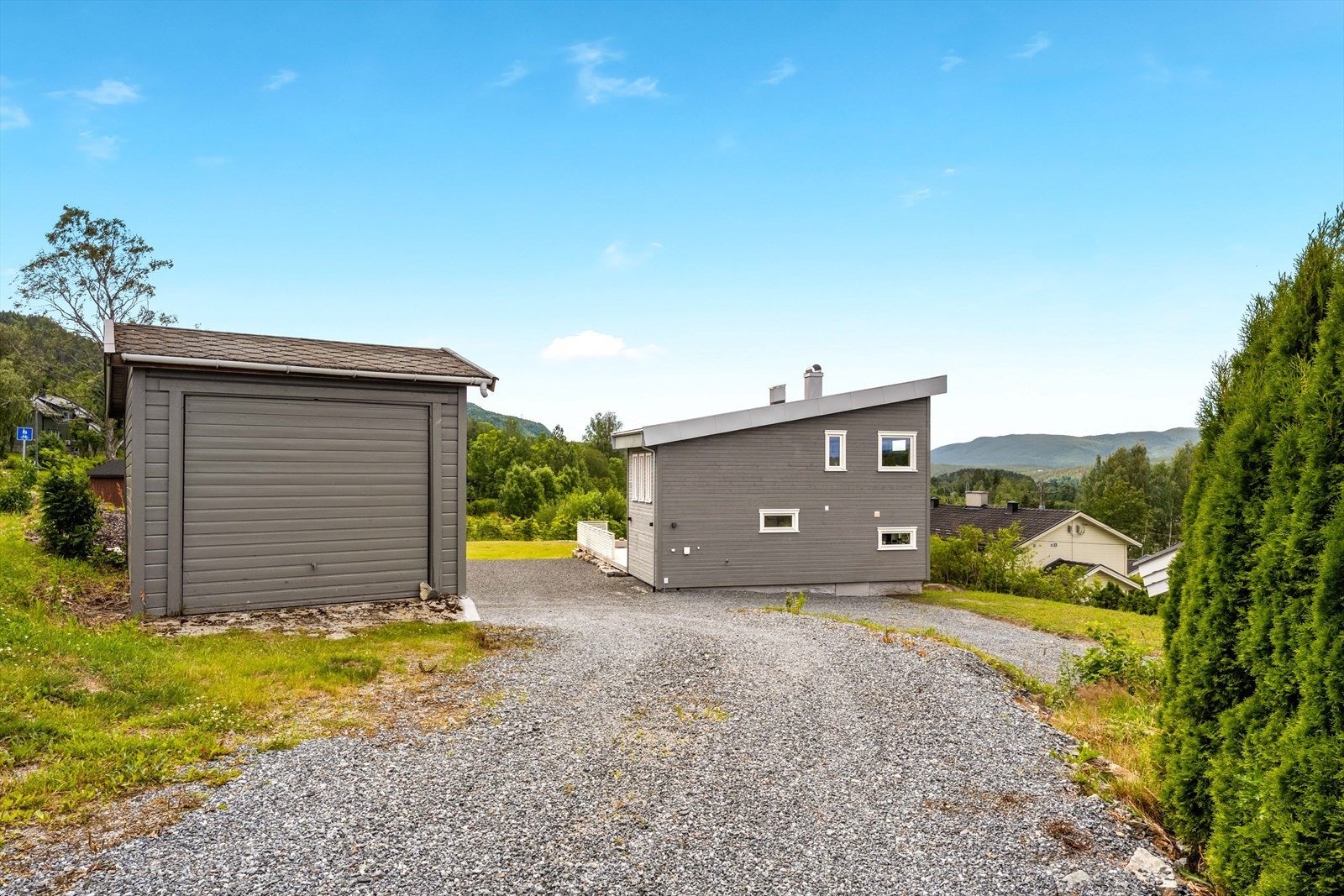Huset ligger innerst i blindvei og ved innkjøring til eiendommen ligger også en frittliggende garasje. Galleribilde