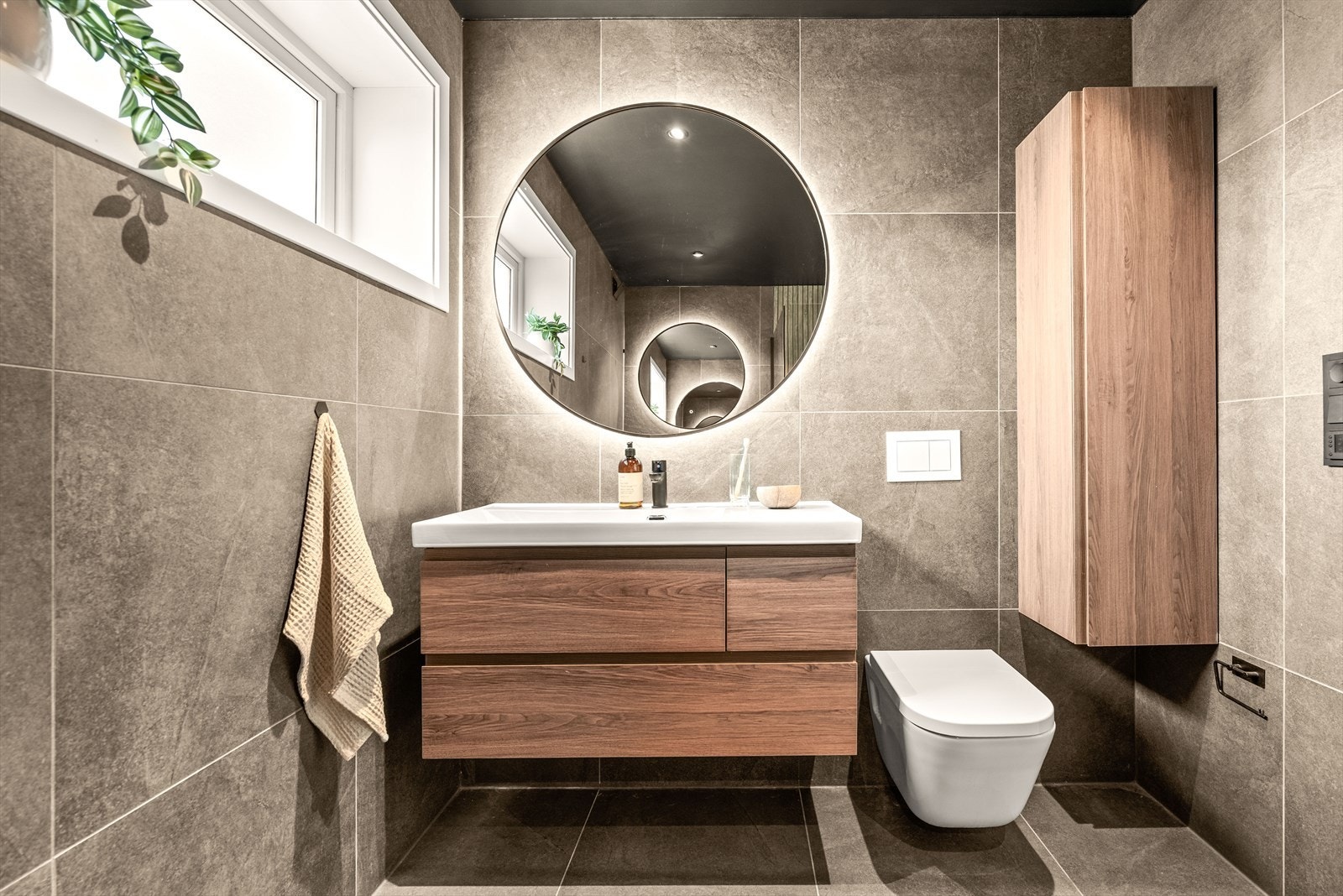 Moderne fliser i storformat og et nordisk innslag i den romslige innredningen, i stil med kjøkkenet. Selvfølgelig varmekabler i gulvet. Galleribilde