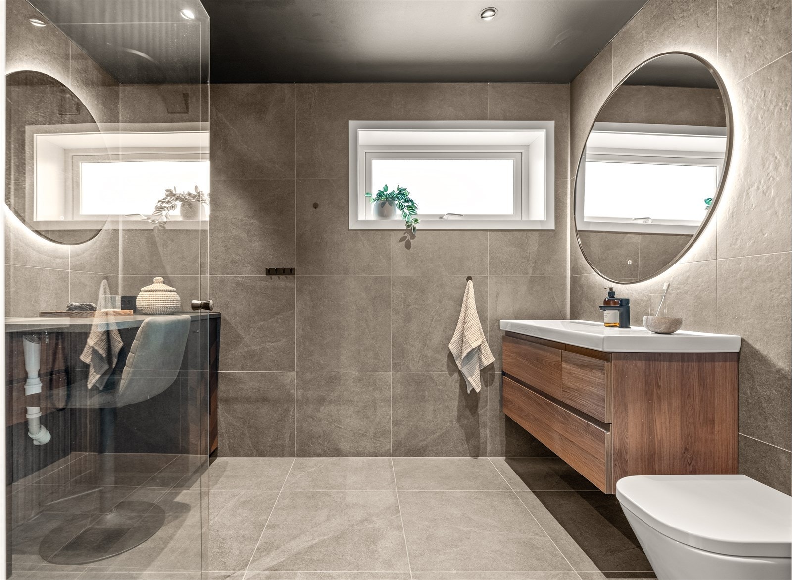 Huset har totalt to baderom, og badet på hovedplan er renovert i 2024 med et eksklusivt og dempet uttrykk. Praktisk sminkebord med eget speil, romslig dusjhjørne og opplegg for vaskemaskin. Galleribilde