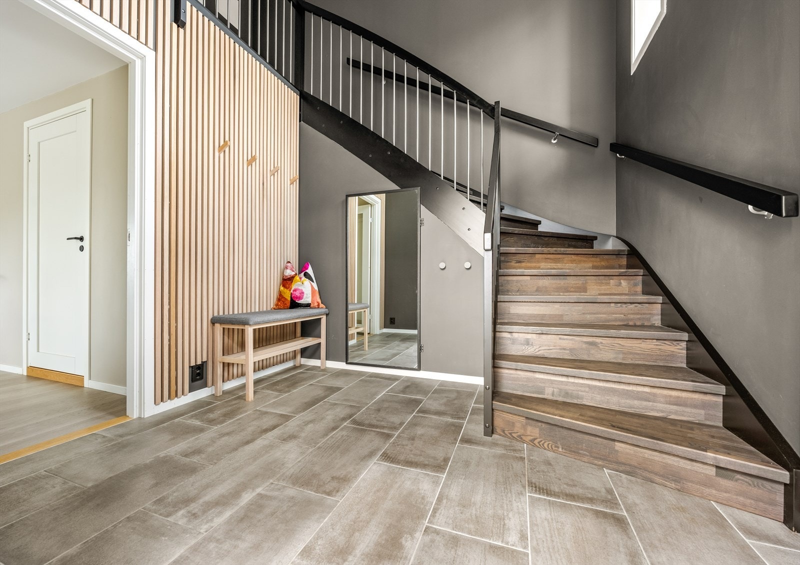 Innbydende hall, hvor et flislagt gulv med varmekabler sørger for enkelt vedlikehold. Gode lagringsmuligheter under trappen med adkomst gjennom speildøren. Galleribilde