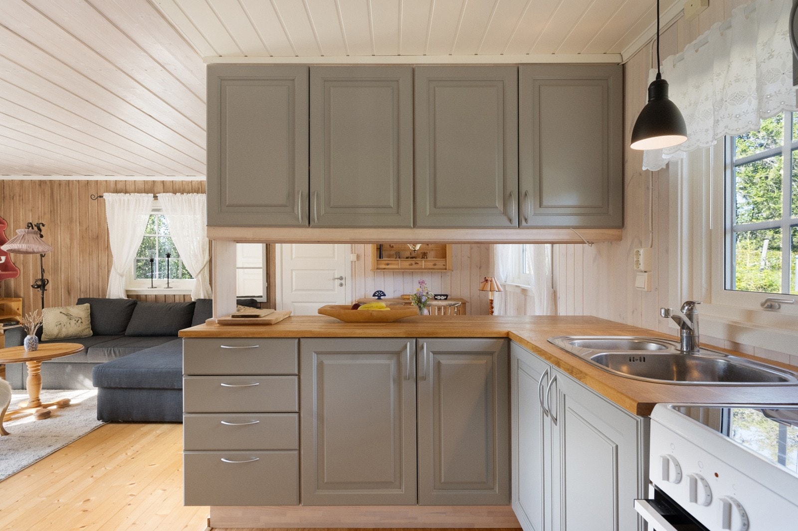 Hytta byr på et pent og praktisk kjøkken med stilfull innredning, der under- og overskap har klassiske, profilerte fronter i en moderne gråtone. Galleribilde