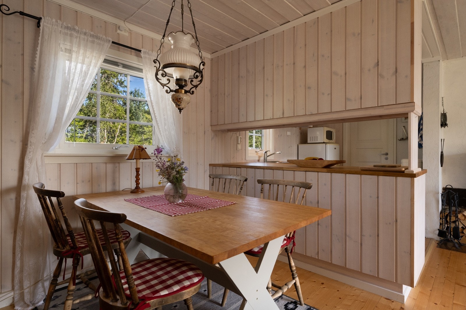 På den andre siden er halvøya kledd med panel og skaper en koselig ramme rundt spiseplassen ved vinduet, hvor man kan nyte utsikten og måltidene i hyggelige omgivelser. Galleribilde