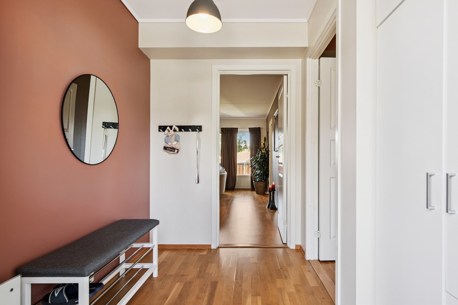 Romslig entré med god plass til benk for av/påkledning, oppbevaring av sko og yttertøy i garderobeskap. Galleribilde
