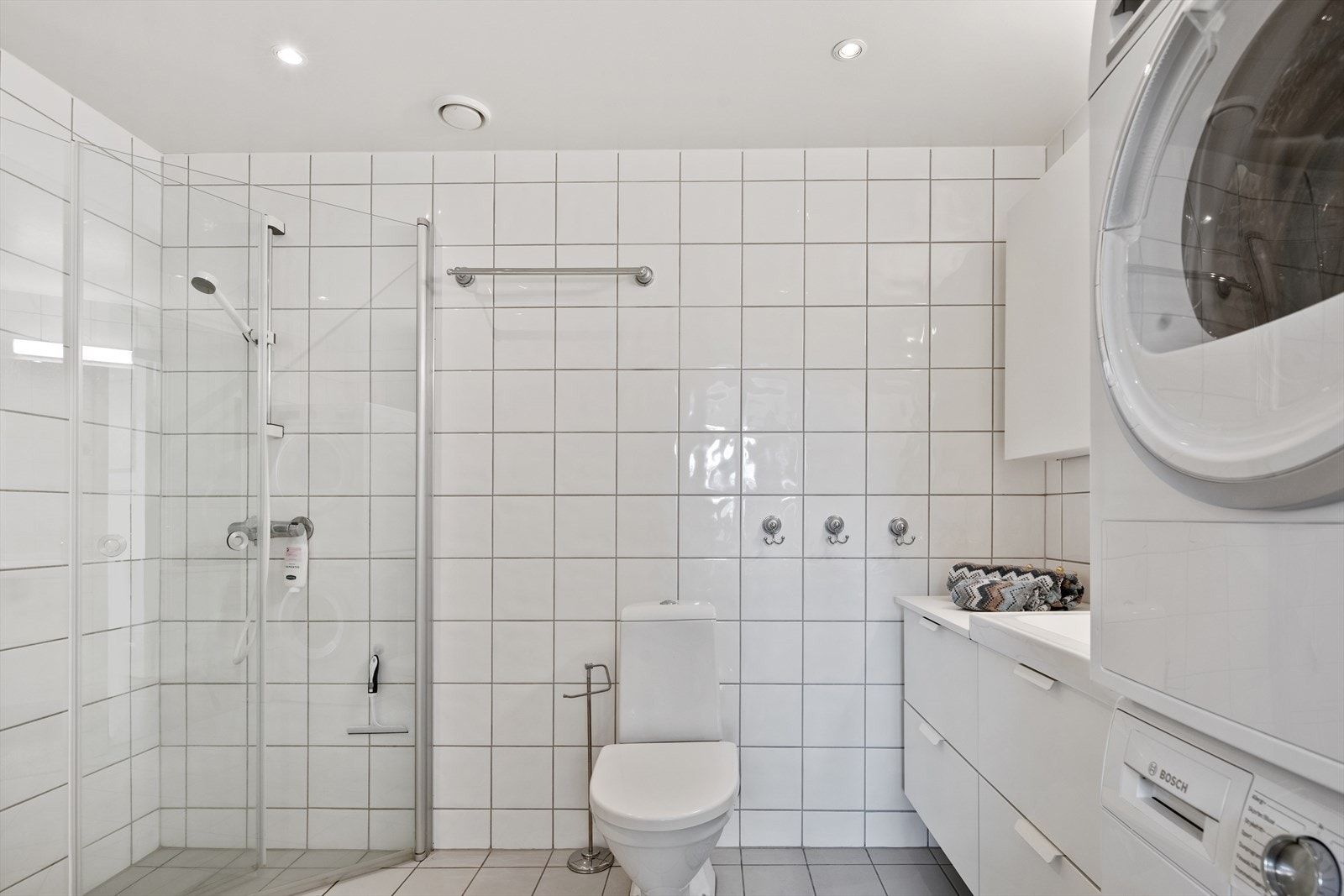 Badet har lyse nøytrale fliser, noe som gjør at at badet oppleves tidløst. Galleribilde