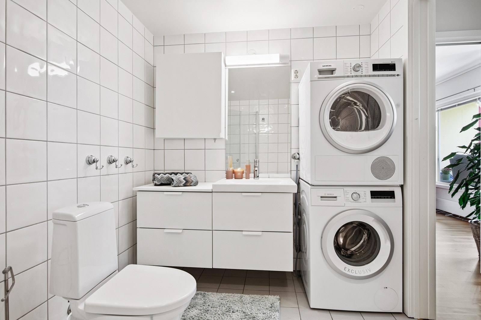 Flislagt bad/vaskerom fra byggeår med plass til vaskemaskin og tørketrommel. Galleribilde