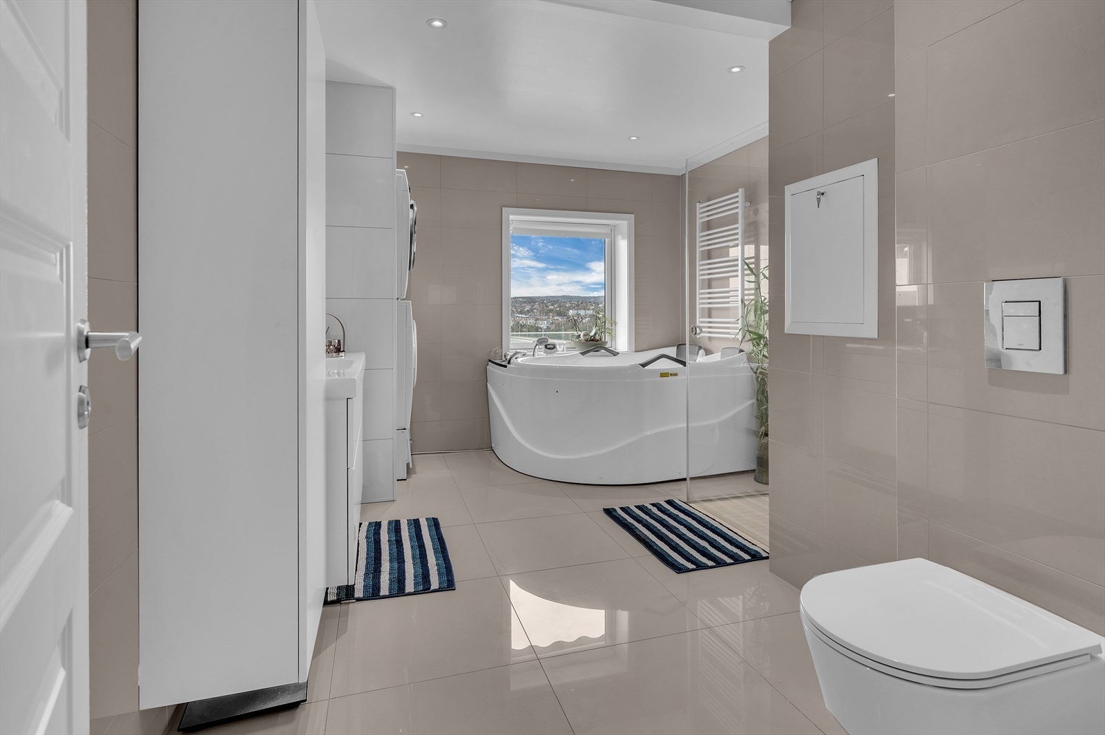 Stort flislagt bad med dusjhjørne og badekar. Galleribilde