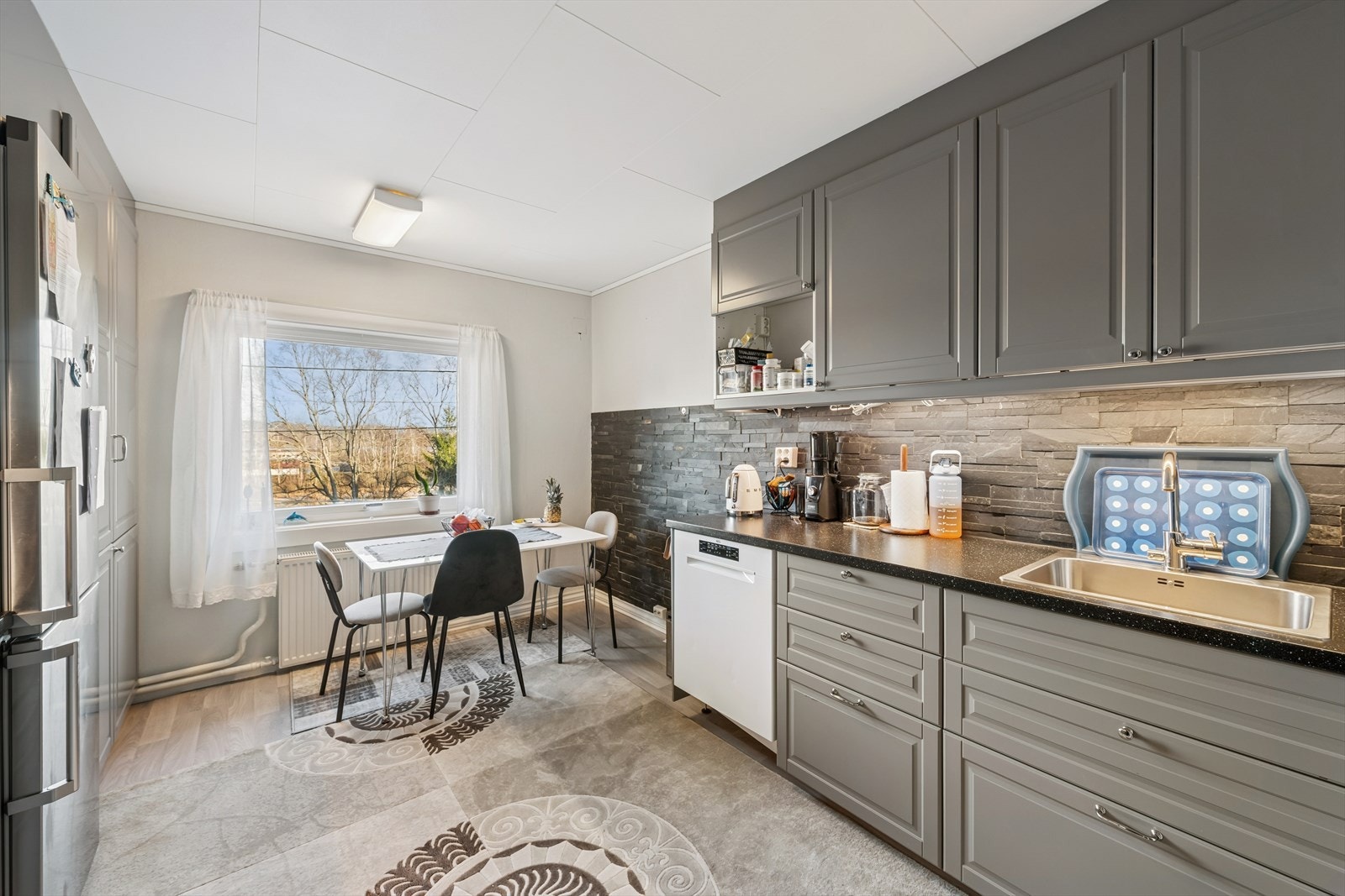 IKEA kjøkkeninnredning fra 2015/2017 med glatte fronter, laminatbenkeplate og oppvaskkum i stål. Galleribilde