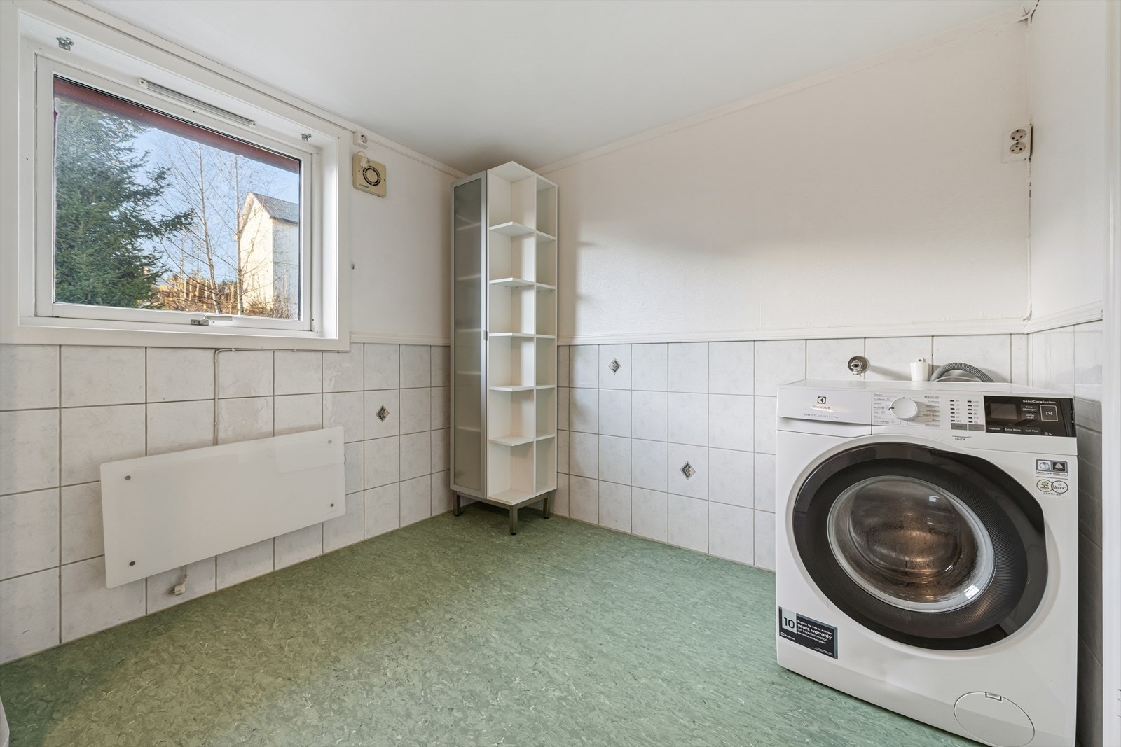 Badet er utstyrt med en servant med slette fronter, et gulvstående toalett, dusjkabinett og har opplegg for vaskemaskin. Galleribilde