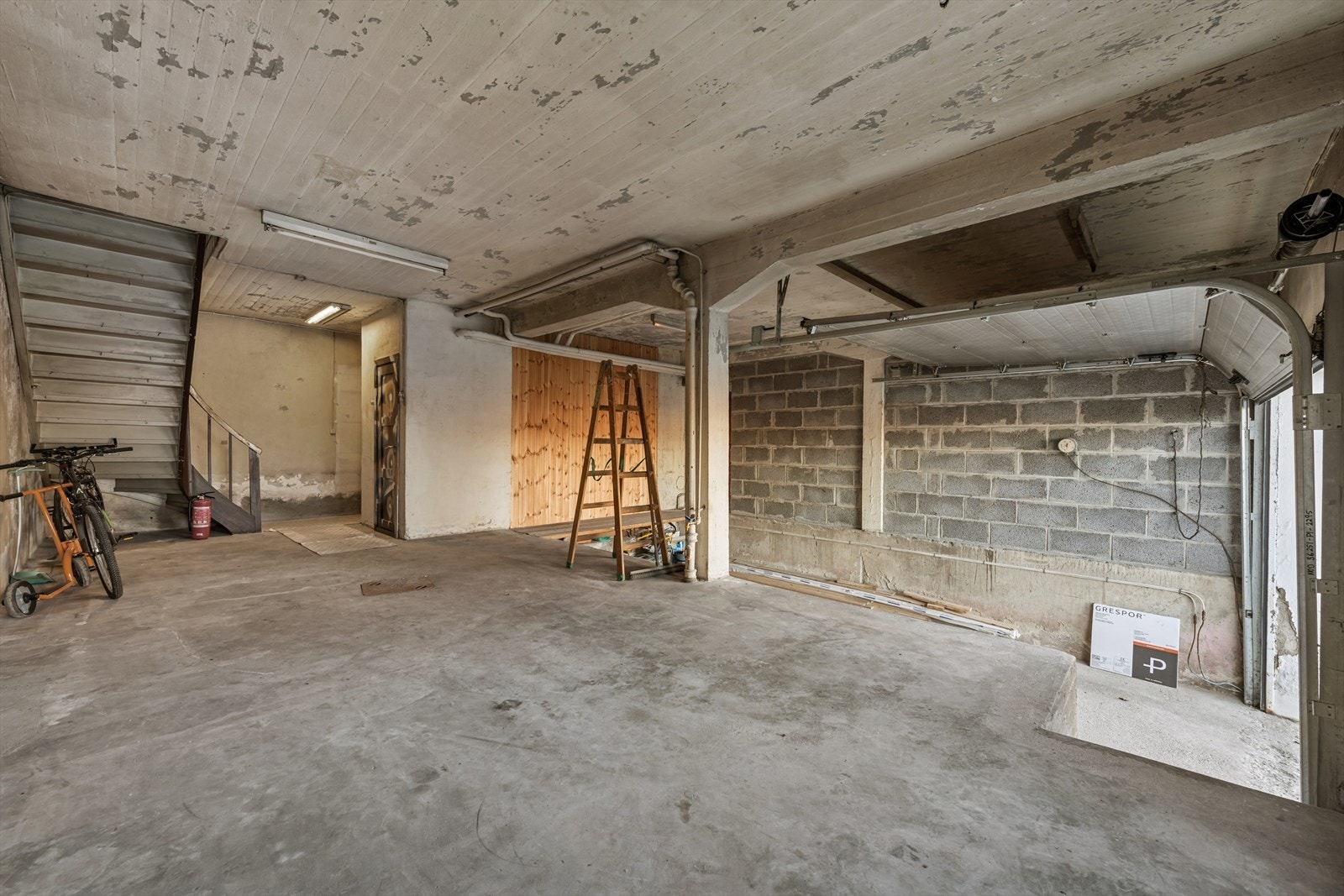 Betongvegger gir solid støtte og stabilitet til rommet, med mulighet for oppbevaring av sykler. Galleribilde