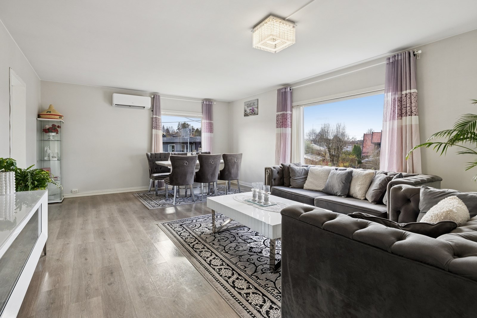 Lys og romslig stue med store vindusflater som gir rikelig med dagslys. Her er det plass til både sofagruppe og spisebord. Galleribilde