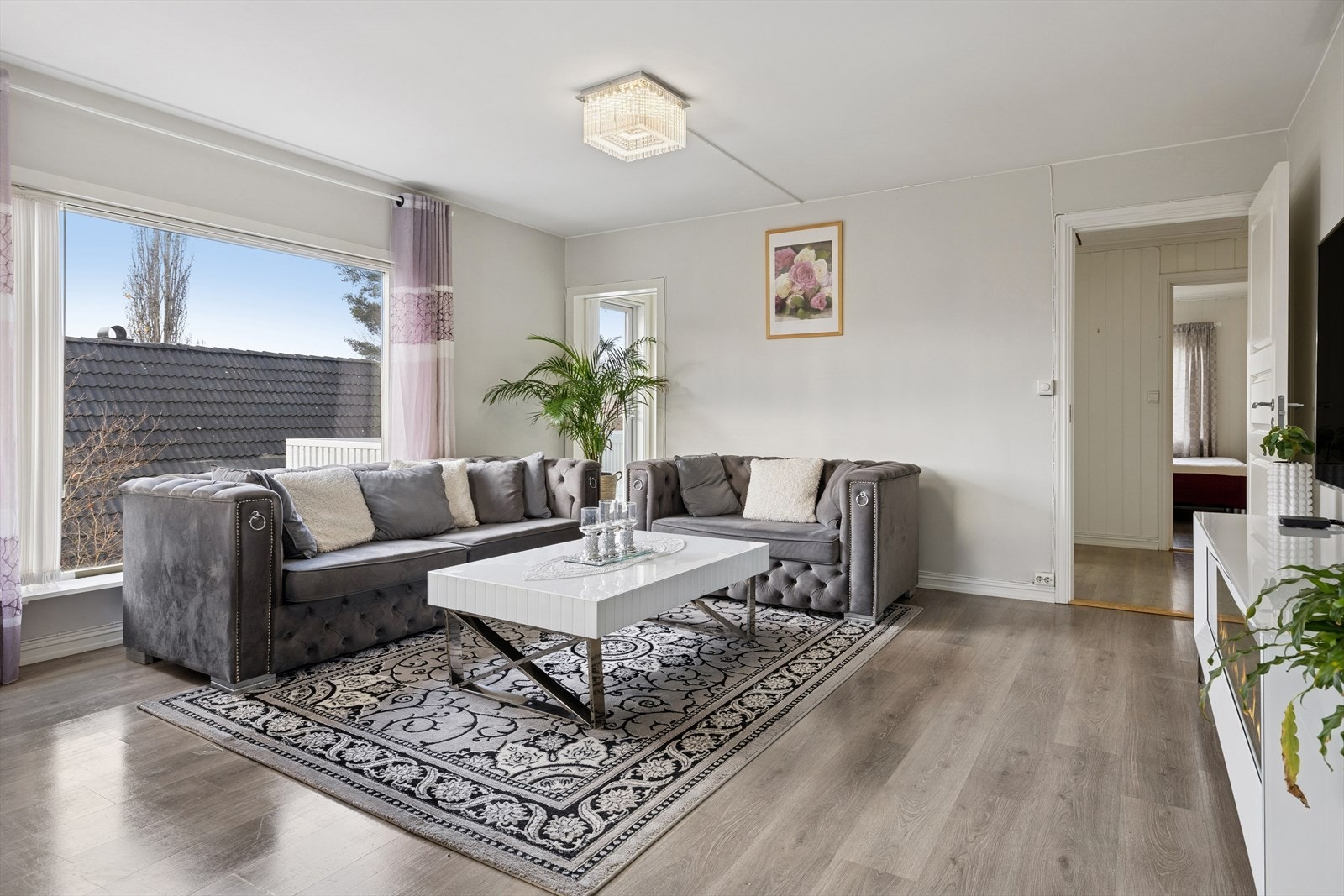 Lys og romslig stue med store vindusflater som gir rikelig med dagslys. Galleribilde