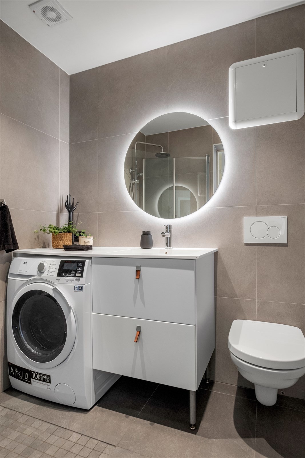 Badet er innredet med baderomsinnredning, praktisk dusjløsning med foldbare dører, toalett og opplegg til vaskemaskin. Galleribilde