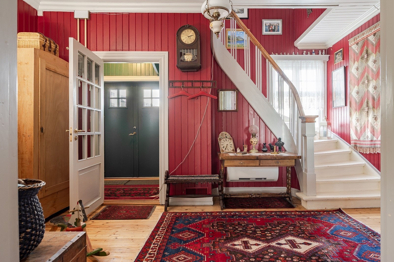 Praktisk entré med plass til sko og yttertøy - videre inn til en romslig hall med vakker trapp til 2. etasje. Galleribilde