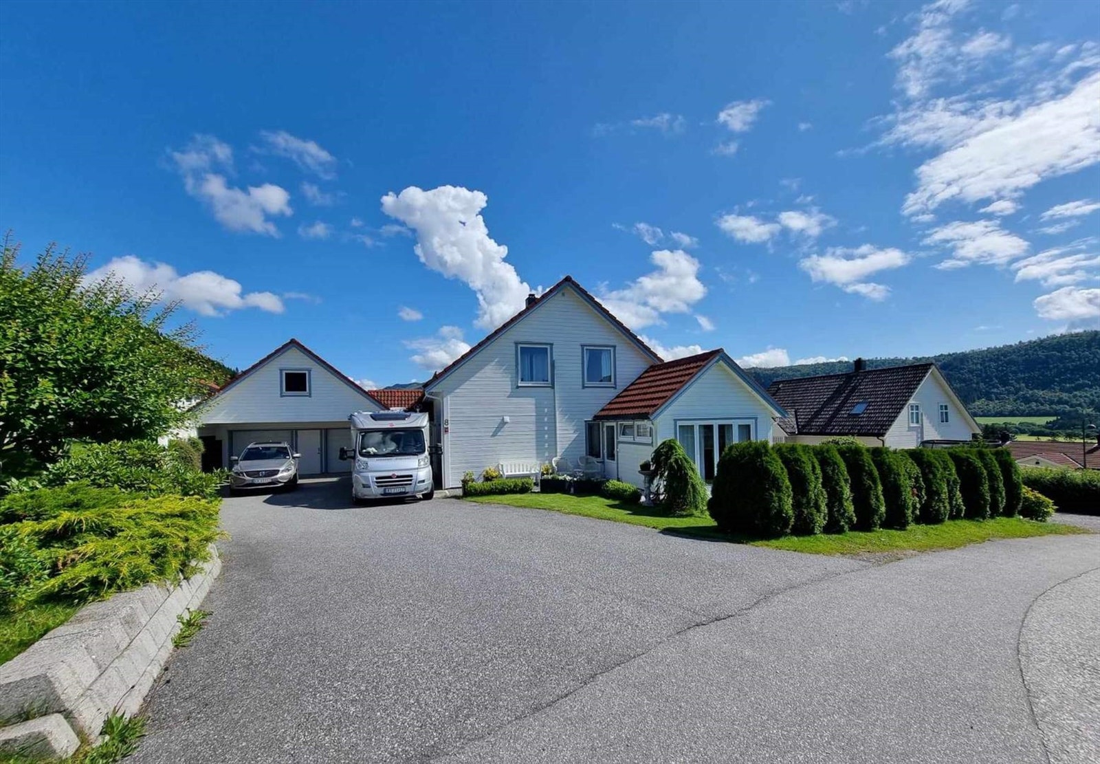 Stor asfaltert innkjørsel med mange parkeringsplasser Galleribilde