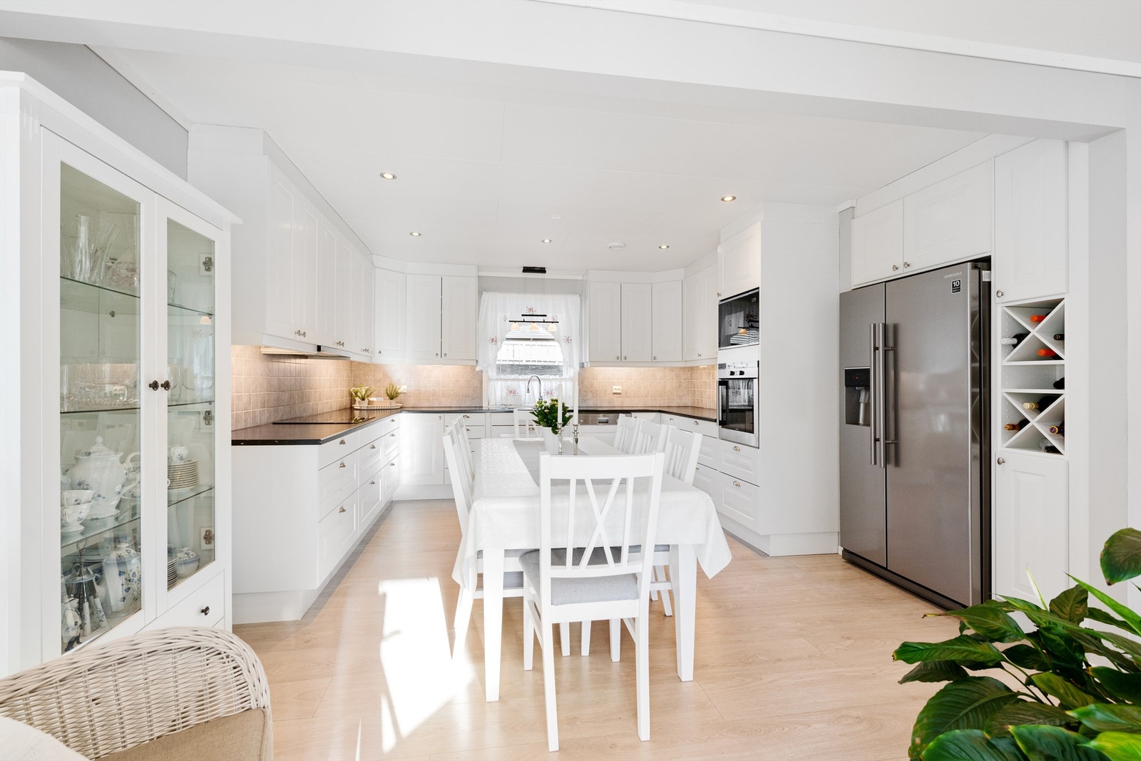 Flott kjøkkeninnredning fra 2013 med hvite profilerte fronter og takhøye skap Galleribilde