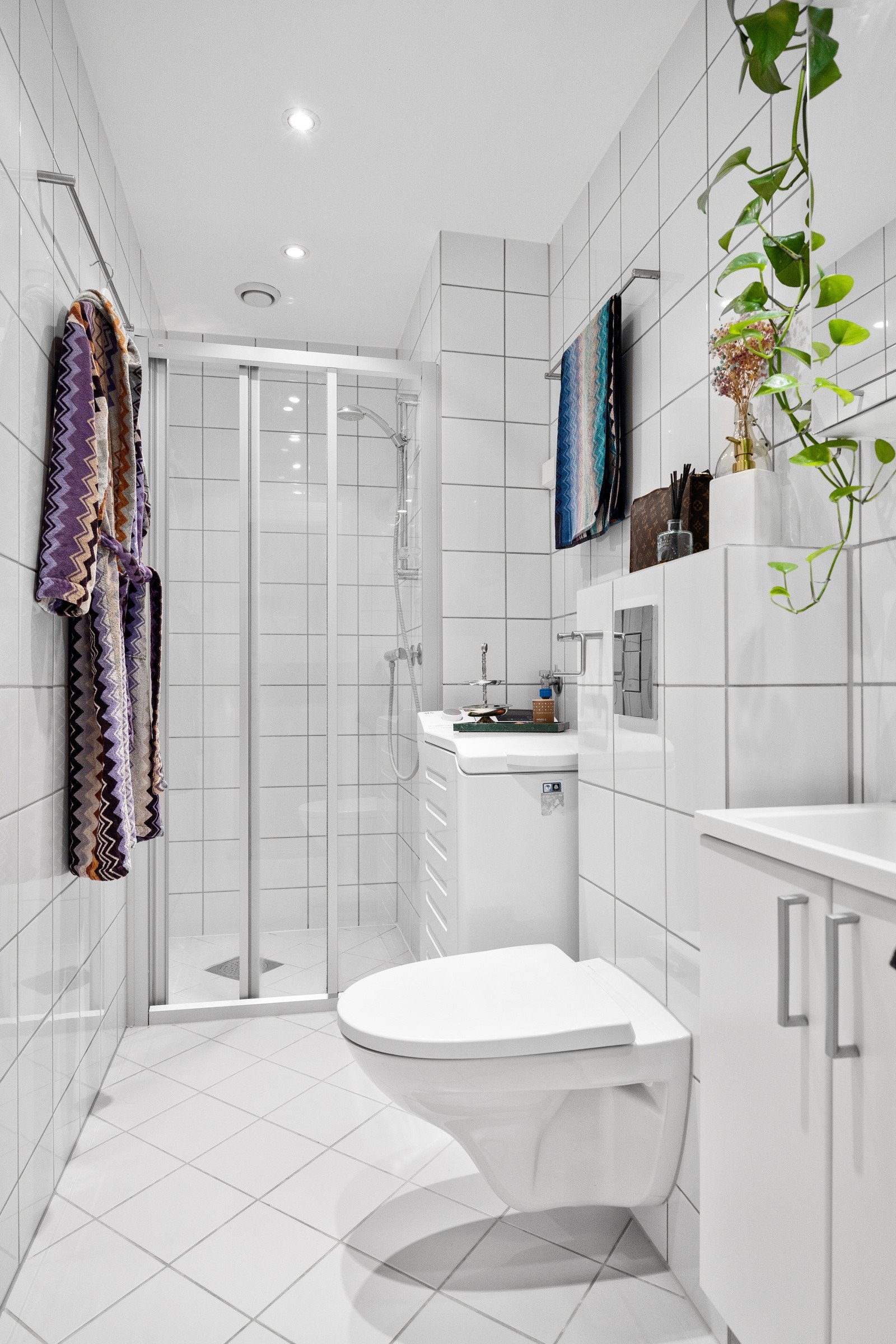 Dusjnisje med dusjvegger, vegghengt toalett, servant med skap og speil. Opplegg for vaskemaskin - Galleribilde