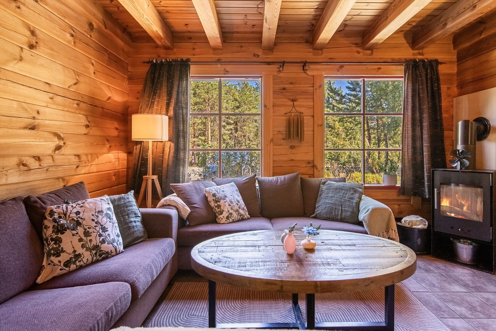 Koselig stue med peisovn og store vindusflater Galleribilde