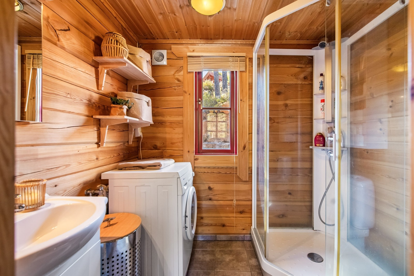 Badet er innredet med wc, dusjkabinett, servant og opplegg til vaskemaskin Galleribilde