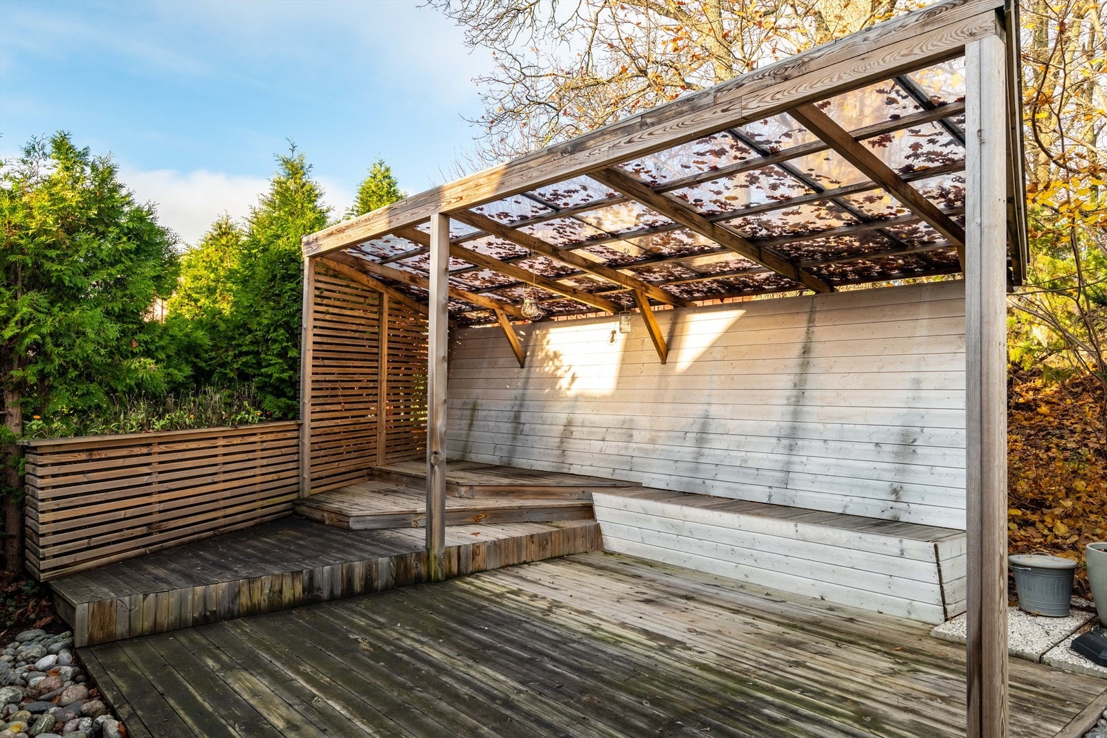 Delvis overbygd uteplass i bakgården med plass til flere sittegrupper Galleribilde