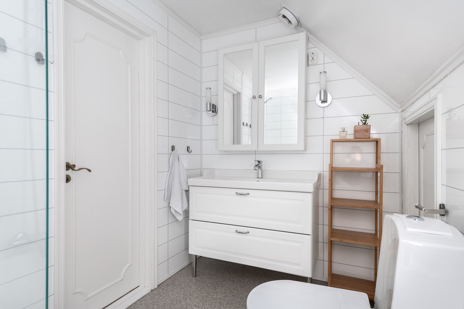 Lyst og pent bad med med lagringsplass i kneloft Galleribilde