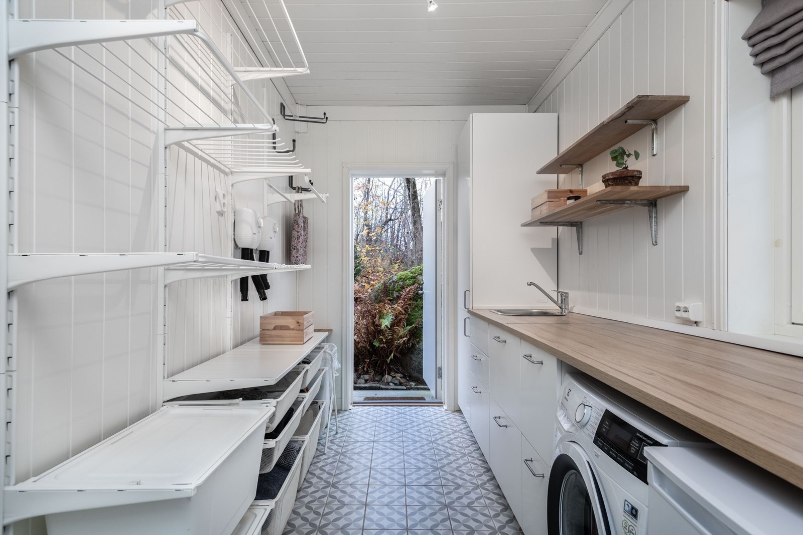Praktisk innredet vaskerom med adkomst fra kjøkkenet og egen utgang mot hagen Galleribilde