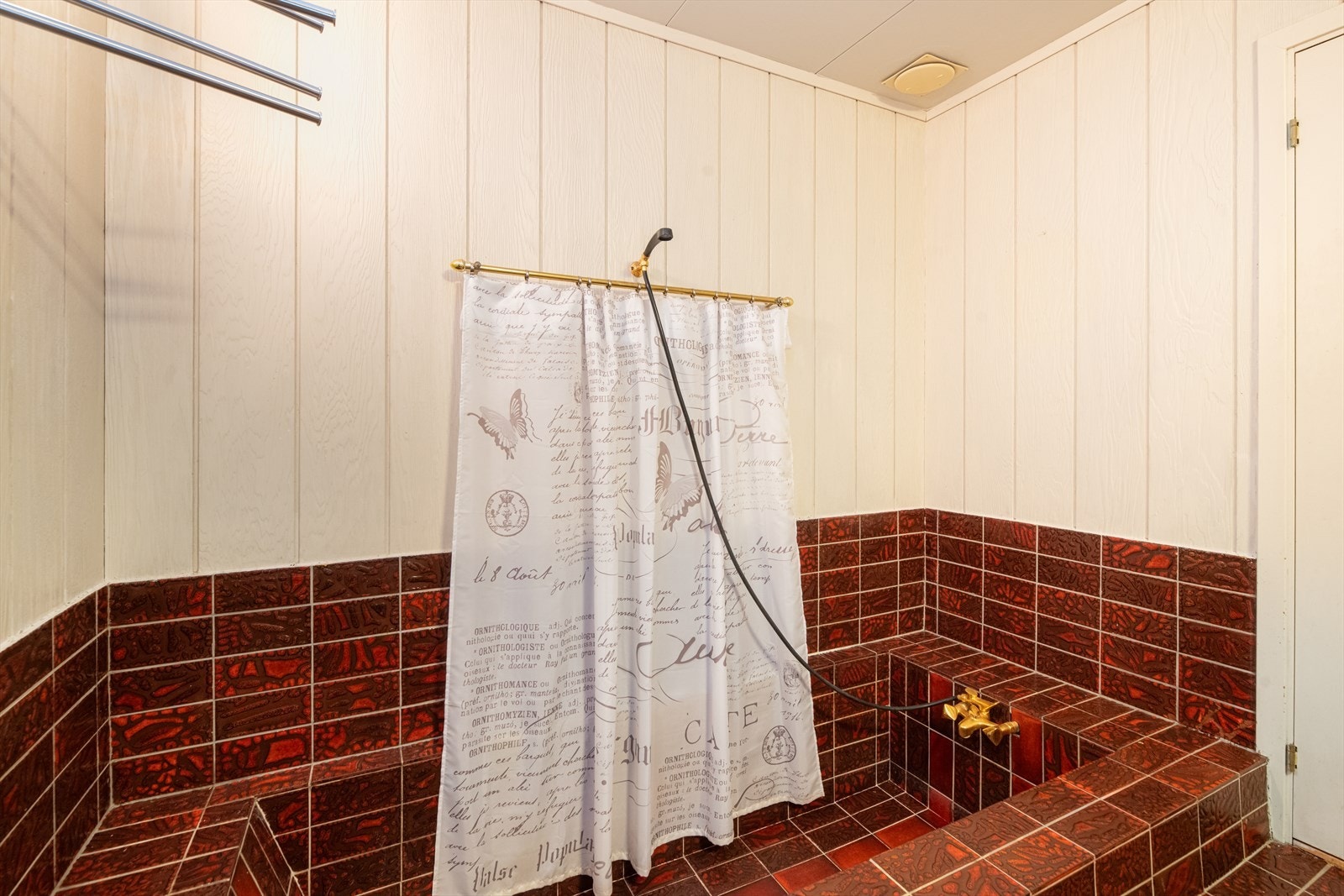 Badet er innredet med innfliset badekar og stor servantinnredning med flere skap, skuffer og speil. Galleribilde