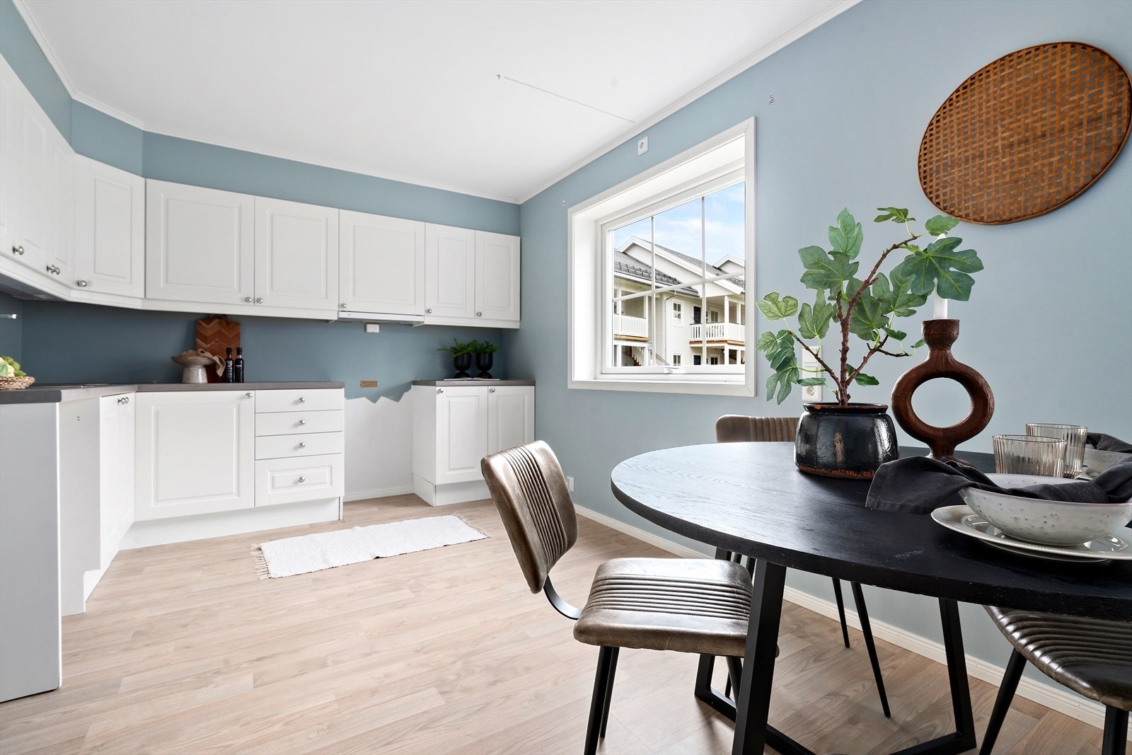 Klassisk og delikat kjøkkeninnredning med hvite profilerte fronter og benkeplate av laminat. Galleribilde