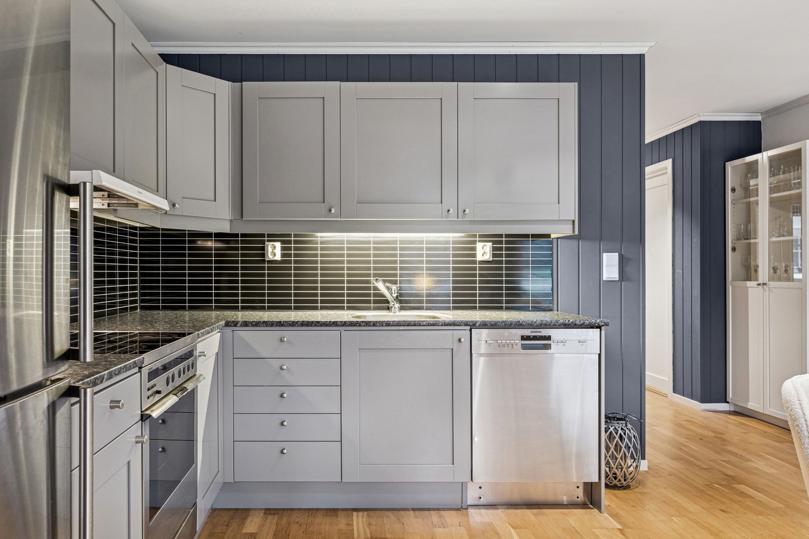 Et pent kjøkken som har godt med skap- og benkeplass. Galleribilde