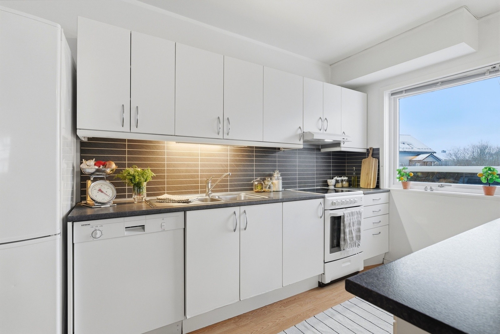 Kjøkkenet har innredning med glatte fronter og benkeplaten av laminat. Galleribilde