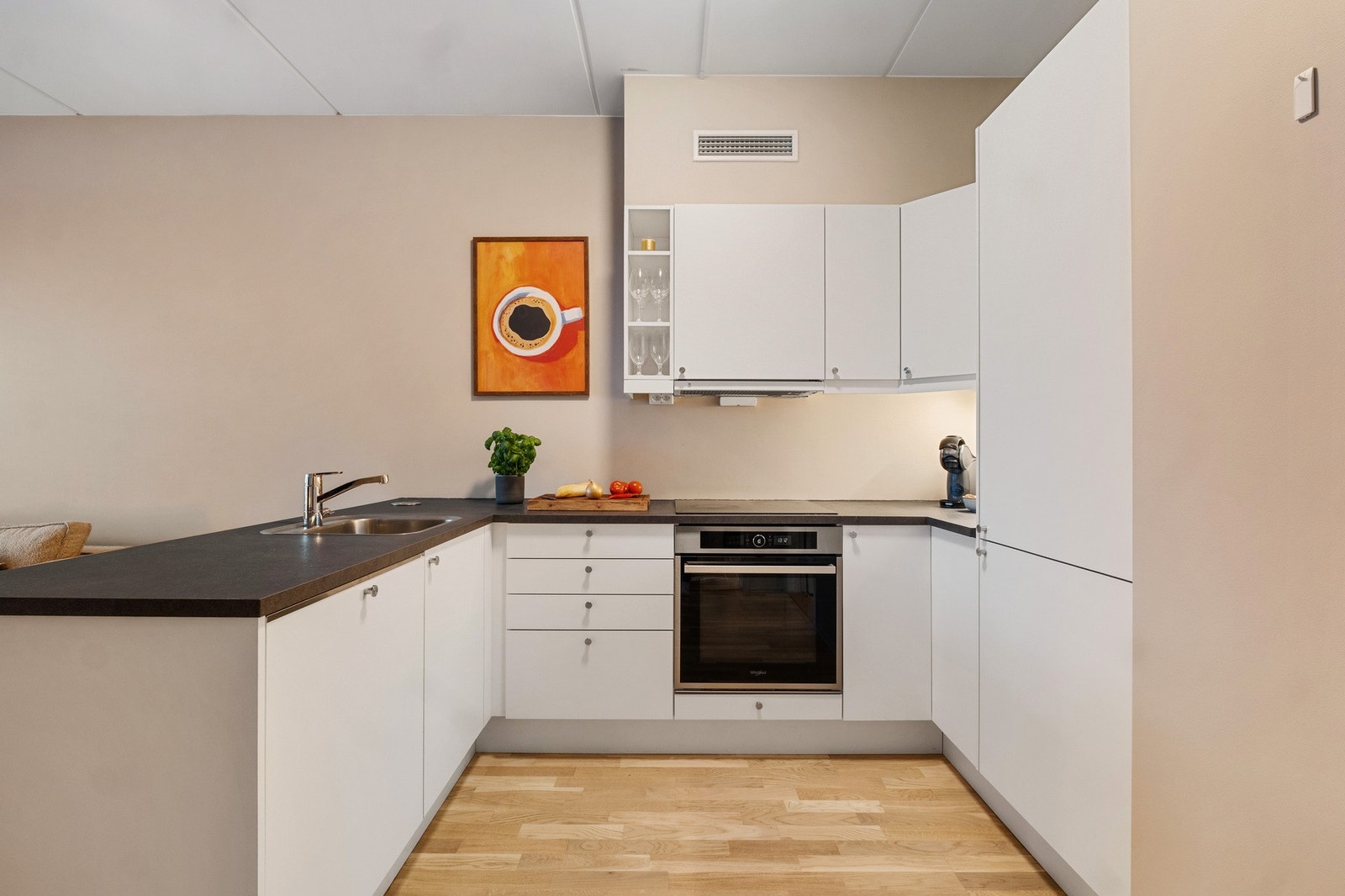 Innredningen er godt utbygget med skap- og benkeplass med komfyr, platetopp, oppvaskmaskin og kjøleskap Galleribilde