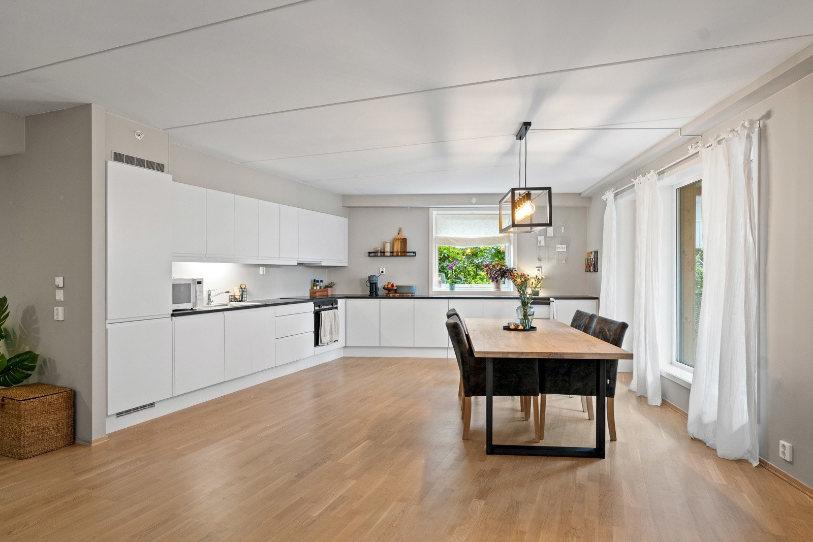 Store vindusflater fra to sider av rommet gir rikelig med naturlig lys Galleribilde