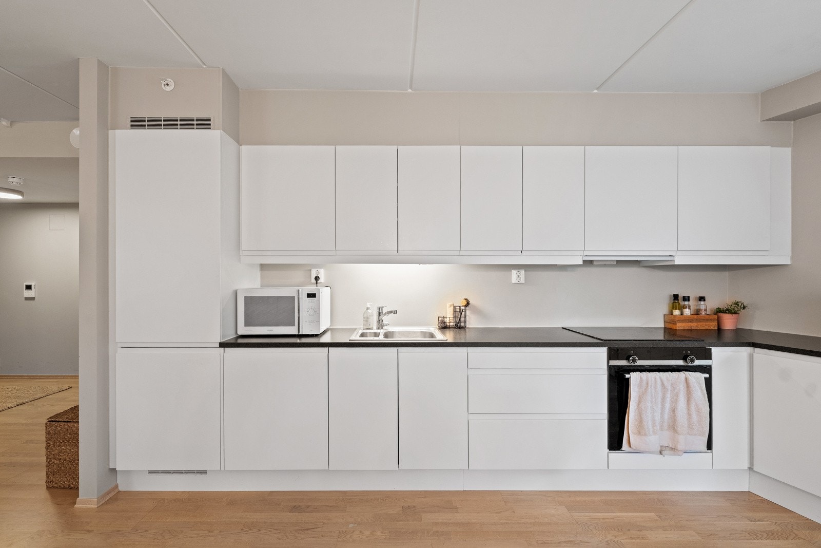 Tidløs kjøkkeninnredning med integrerte hvitevarer samt god skap- og benkeplass Galleribilde