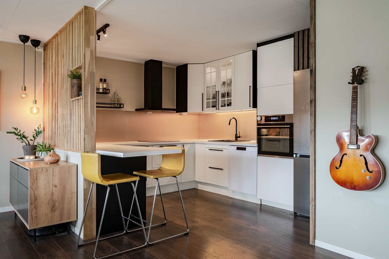 Kjøkkenet har en praktisk utforming med en halvøy som sørger for god skap- og benkeplass, samt en hyggelig sitteplass med barstoler. Galleribilde