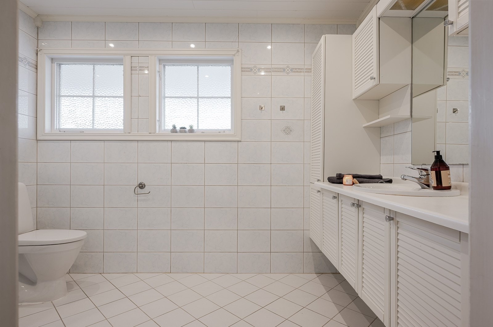 Boligen har et lyst eldre baderom fra ukjent årstall. Baderommet har fliser på gulv og vegger, elektrisk gulvvarme, downlights i himlingen og elektrisk styrt vifte. Galleribilde