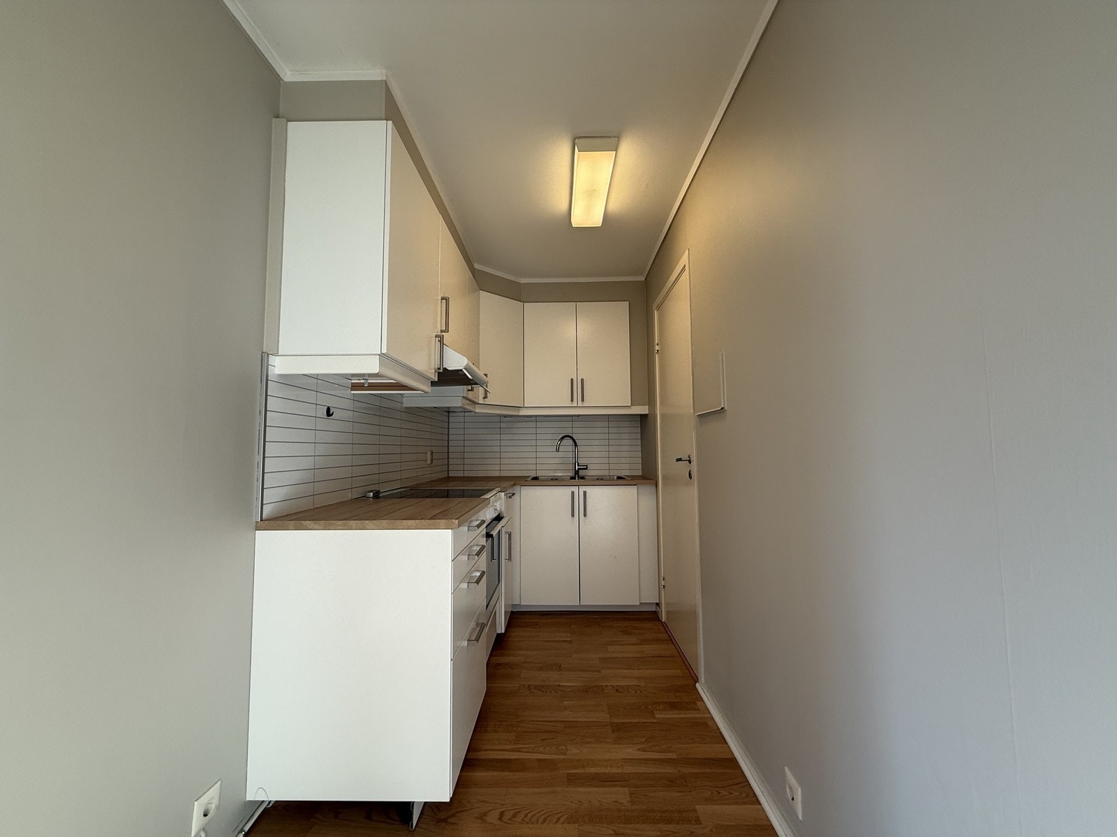 Kjøkken i hvite fronter med god skap og benkeplass. Galleribilde