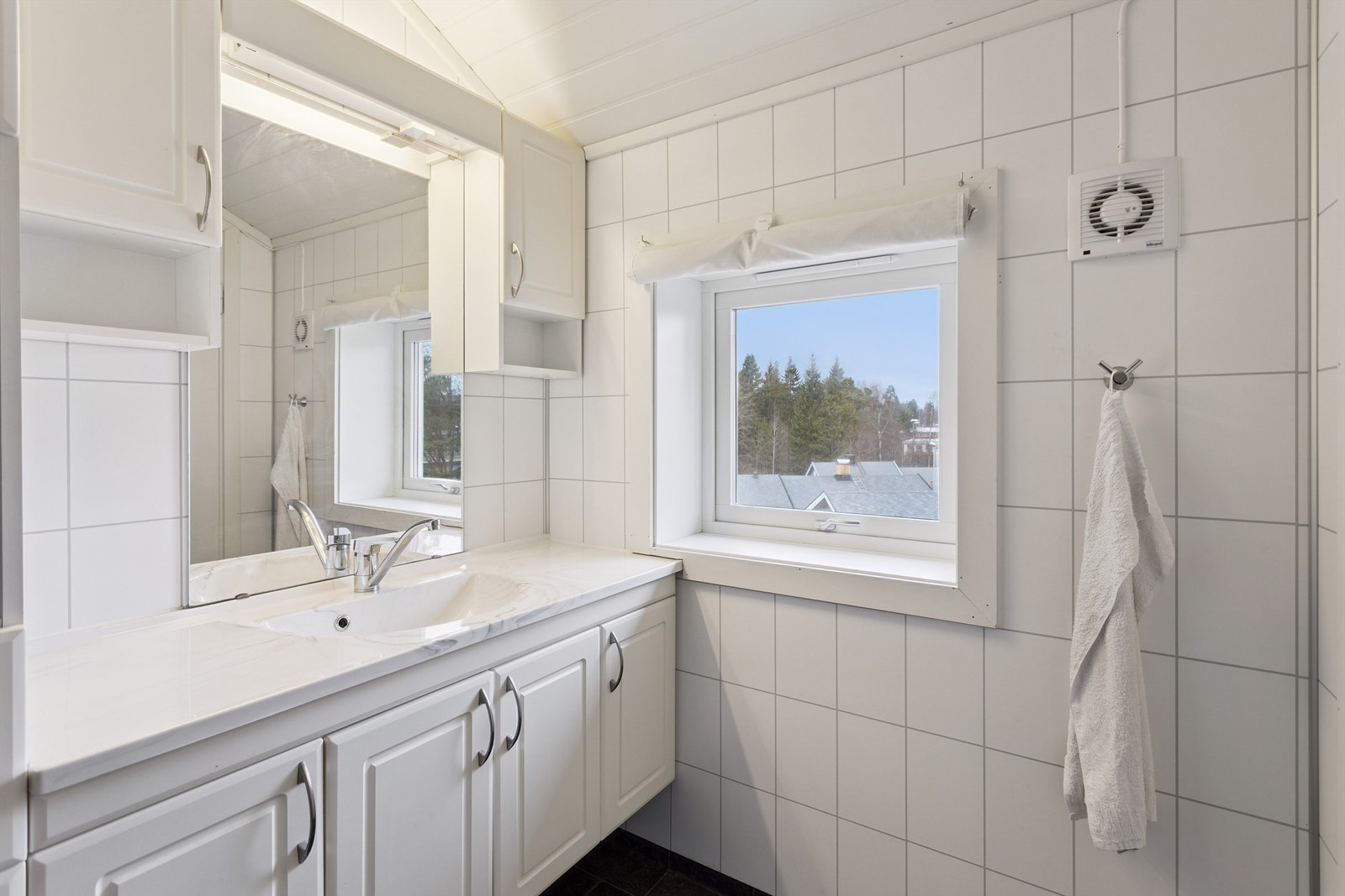 Baderommet i andre etasje har flislagte vegger og et vindu som gir naturlig lys. Galleribilde